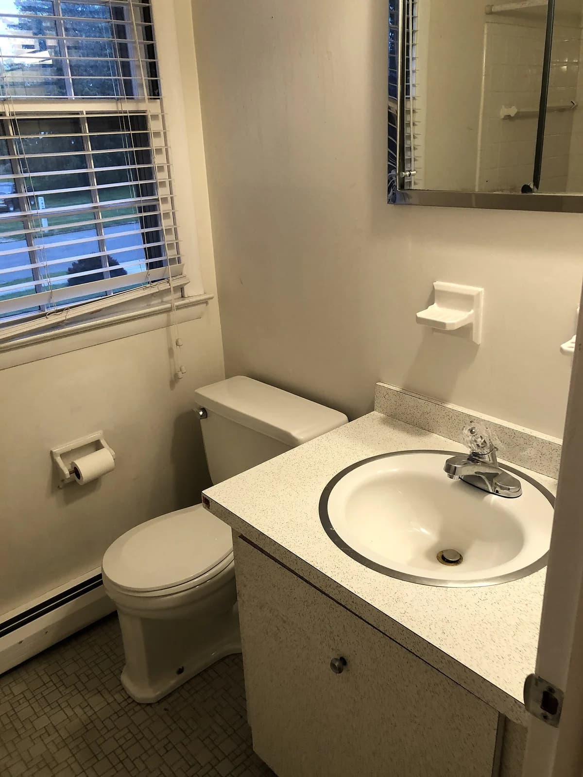 Residential bathroom with a pedestal-style toilet and vanity sink installed