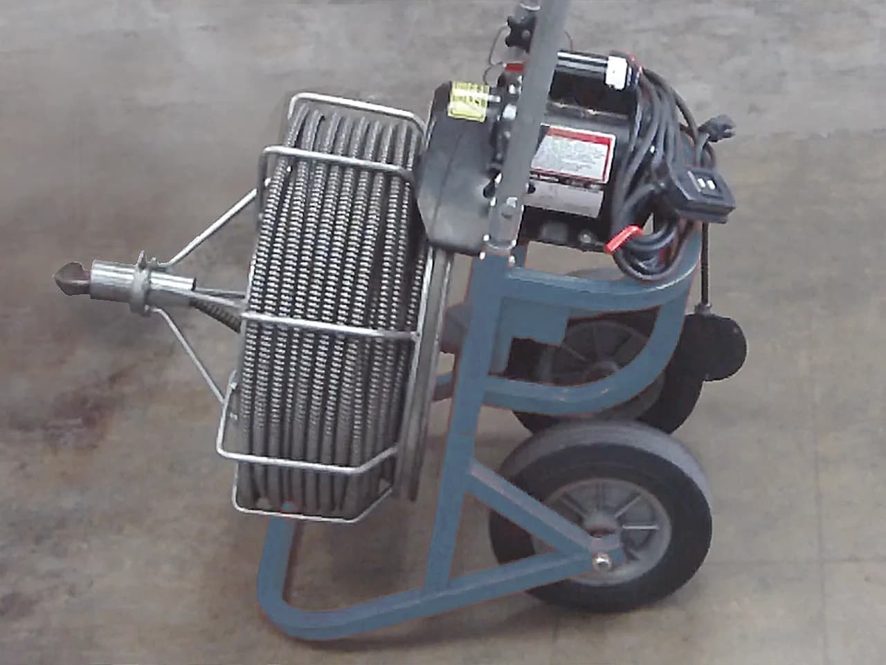 Electric drum auger drain-cleaning machine with coiled cable on a wheeled cart