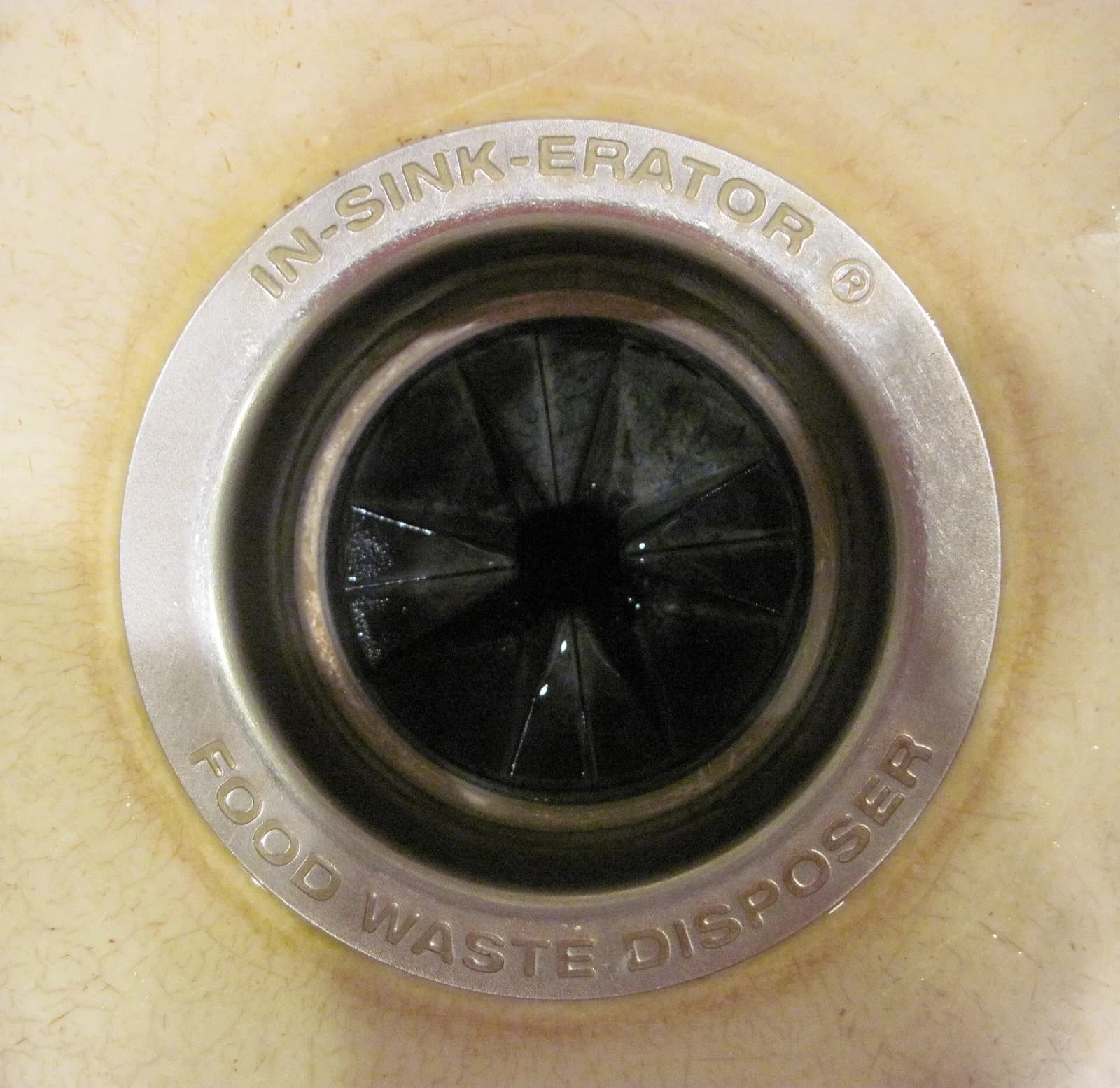 Close-up of a garbage disposal unit installed beneath a kitchen sink