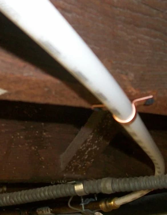 Flexible PEX water supply piping bent and routed through floor joists in a basement