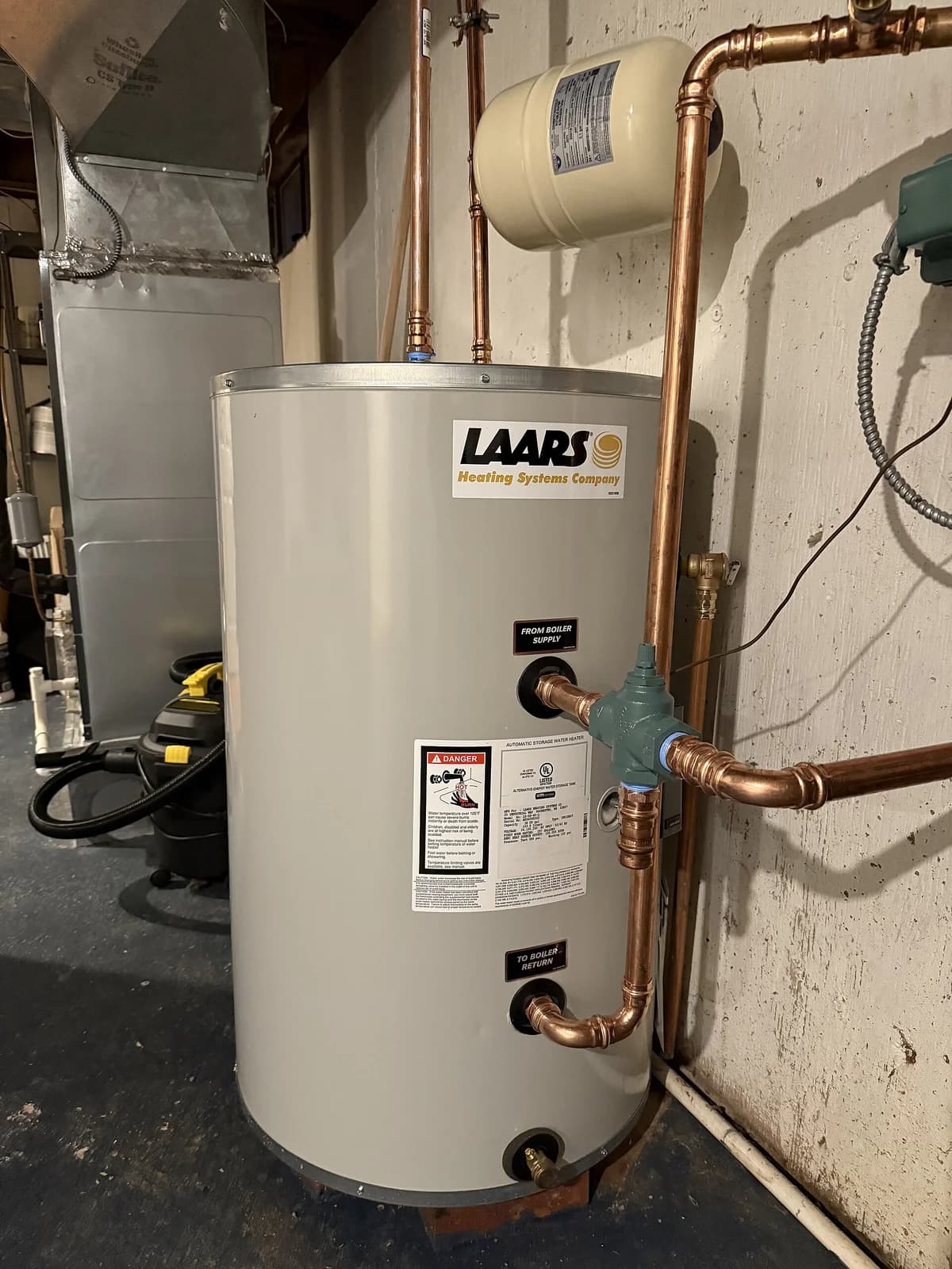 Newly installed residential tank water heater with fresh copper and PVC connections